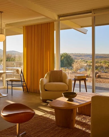 Golden-hour living room with desert view through floor-to-ceiling glass