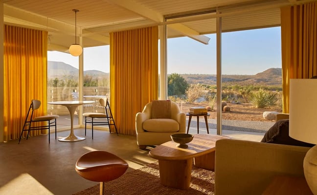The Bungalows golden-hour living room with desert view through floor-to-ceiling glass
