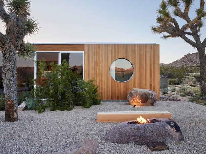 Landing House exterior with fire pit and Joshua trees at dusk